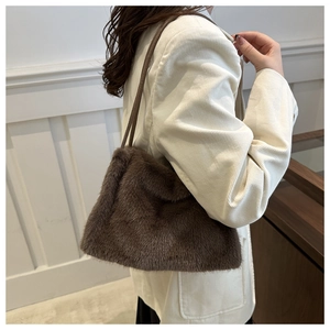 Detail of dark brown faux mink fur tote bag paired with white corduroy blazer