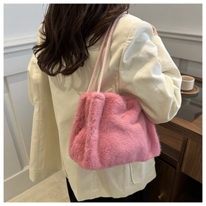 Close-up of soft pink faux fur shoulder bag worn with a white corduroy jacket