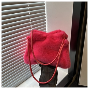 Detail of bright pink faux fur shoulder bag with soft plush texture and leather strap