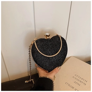 Detail of a sparkling heart-shaped evening clutch bag with black sequins and crystal clasp