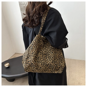 Large leopard print tote bag with front flap pocket shown on a model's shoulder