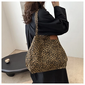 Detail view of leopard print tote bag with large front pocket and sturdy shoulder straps