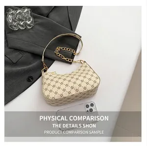Detailed top view of a cream half-moon bag with gold chain and monogram pattern