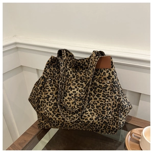 Detailed close-up of large capacity leopard print tote bag with silver rivet pocket accents