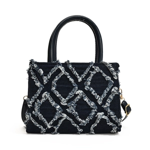 Navy blue denim quilted tote bag with white tassel details and black top handles