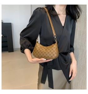 Close-up of retro brown hobo bag featuring geometric star patterns and gold hardware