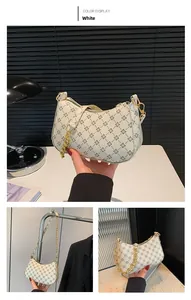 Detail of white vintage floral shoulder bag with golden chain and adjustable strap