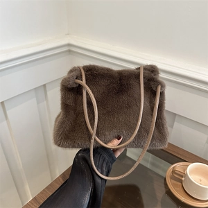 Brown faux fur shoulder bag with thin straps shown in a cozy lifestyle setting