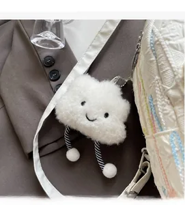 Close-up of cute white plush cloud charm with smiley face on a backpack