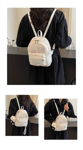 Detail view of mini white backpack with macaron embroidery and plush cloud charm