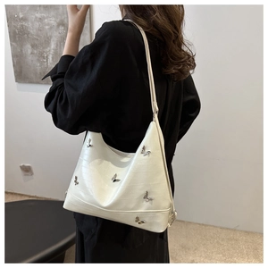 White faux-crocodile underarm bag featuring 3D silver butterflies and a slim shoulder strap