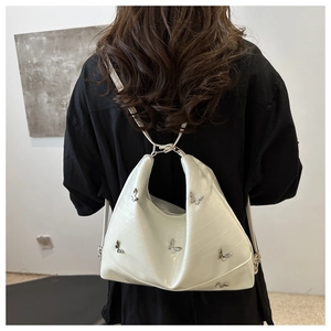 Close-up of white crocodile pattern PU leather bag with silver metal butterfly charms