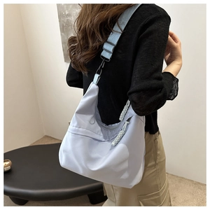 Detailed side view of light blue nylon crescent tote bag with woven rope zipper detail