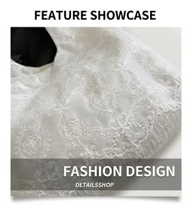 Close-up of white lace embroidery fabric featuring detailed floral hollow-out patterns