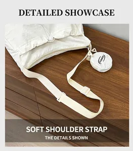 Detail of soft shoulder strap and mini round pendant on white canvas tote bag