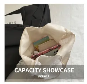Spacious interior of white lace canvas tote bag holding a phone, wallet, and notebooks