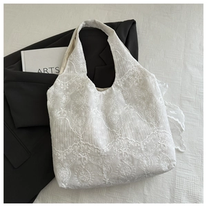 Detail shot of the white lace tote bag with delicate floral embroidery texture