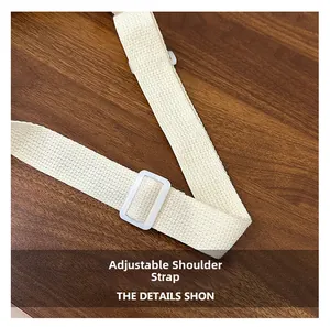Detail view of a white adjustable woven canvas shoulder strap with a durable plastic buckle
