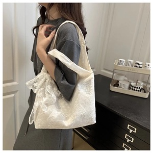 Detailed shot of white floral lace tote bag featuring a large decorative bow