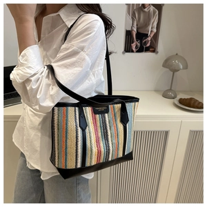 Détail du sac cabas en paille à rayures verticales colorées avec anses en simili cuir noir