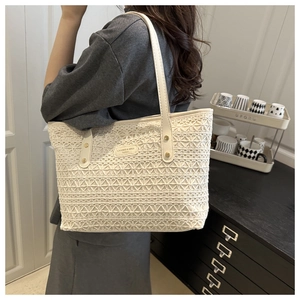 Detail of white lace crochet pattern on large tote bag with cream leather handles