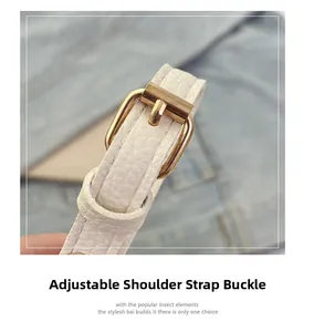 Détail de la boucle dorée réglable sur la bandoulière en cuir blanc grainé