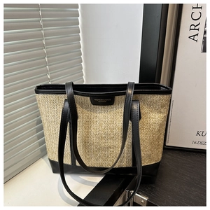 Détail du sac cabas en paille tissée avec garniture en cuir noir et coutures contrastées