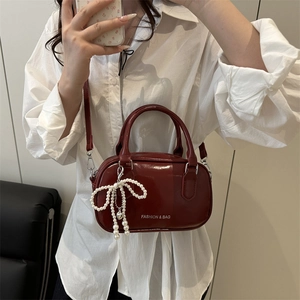 Sac Boston rétro en cuir verni bordeaux avec breloque nœud perle et lettrage argenté
