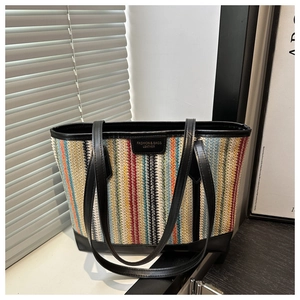 Détail du cabas tissé à rayures colorées avec poignées et étiquette en cuir noir premium