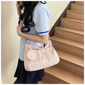 Detailed view of pink drawstring shoulder bag with pleats and matching coin purse charm