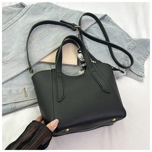 Détail du sac seau en cuir grainé noir avec foulard en soie et clous de fond dorés