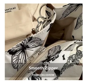 Close-up of a smooth silver zipper and interior lining of a large canvas butterfly tote bag
