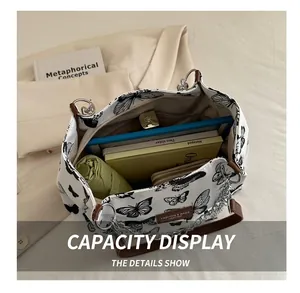 Detail showing high-capacity white canvas tote bag interior with butterfly print design