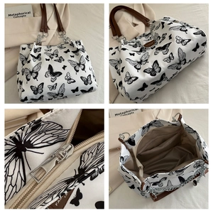 Detail of butterfly print canvas tote bag featuring leather handles and interior zip pocket