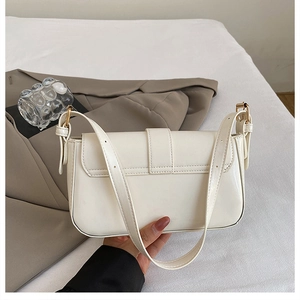 Detailed close-up of cream off-white leather shoulder bag with gold metal buckle hardware