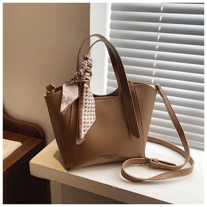 Détail du sac seau en cuir litchi marron avec foulard et bandoulière réglable