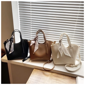 Vue détaillée de grands sacs seaux en cuir grainé avec des foulards en soie décoratifs
