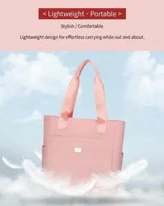 Detail showing the lightweight pale pink nylon tote bag with metal logo and side pockets