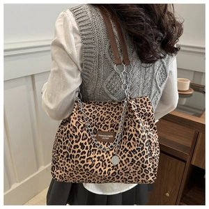 Detail of leopard print tote bag with metal chain strap and leather fashion label