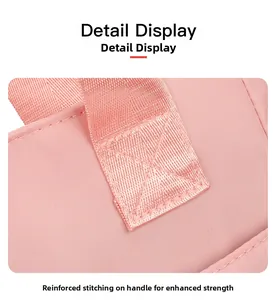Close-up of reinforced stitching on the handle of a pink nylon tote bag for durability