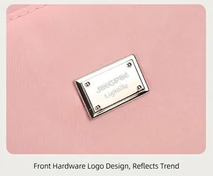Detail of pink nylon fabric with silver JINGPIN metal logo plate on a tote bag