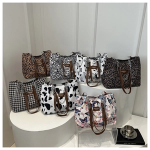 Variety of printed canvas tote bags with leopard, zebra, and floral designs on display
