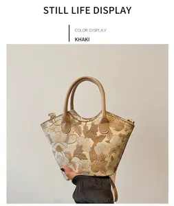 Close-up of floral embroidery on a khaki tote bag with a leather handle and retro design