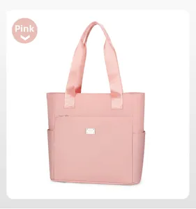 Close-up of pink nylon tote bag with metal nameplate and functional side pockets