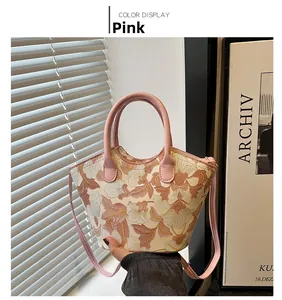 Detailed pink floral tote bag with embroidery, showing dual handles and slim shoulder strap