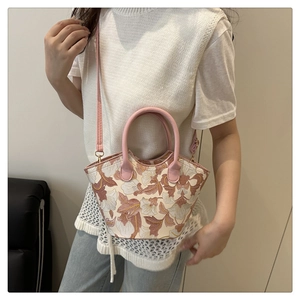 Detail of floral embroidery on pink and beige tote bag with shoulder strap