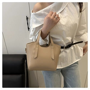 Detailed view of beige pebble leather tote bag with reinforced handles and metal D-rings