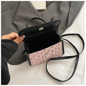 Detail of pink heart-patterned bag showing magnetic closure and interior compartment