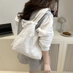 White lace tote bag with floral embroidery and large bow accent for summer style