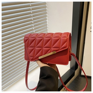 Détail du sac bandoulière matelassé rouge avec bordure dorée et motifs de broderie élégants